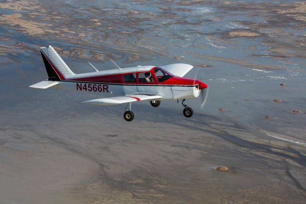 A Piper Cherokee 140 in the air over the Great Salt Lake