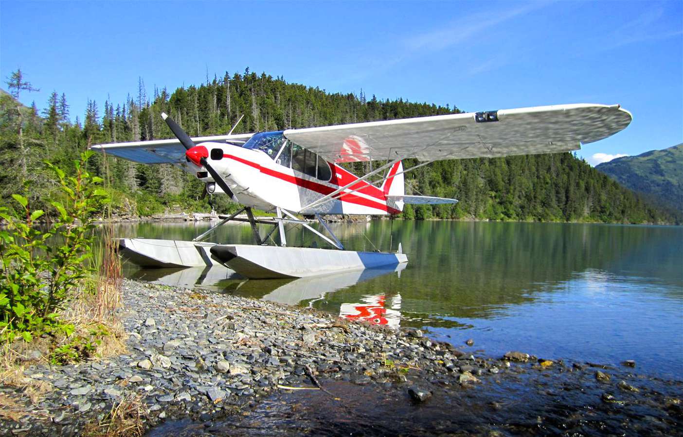 A seaplane docked in a small Alaskan glacial lake.