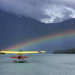 A seaplane on a beautiful Alaskan lake with a rainbow.