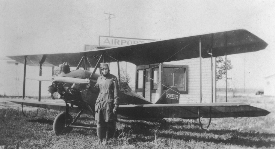 Amelia Earhart standing next to her Kinner Airster.