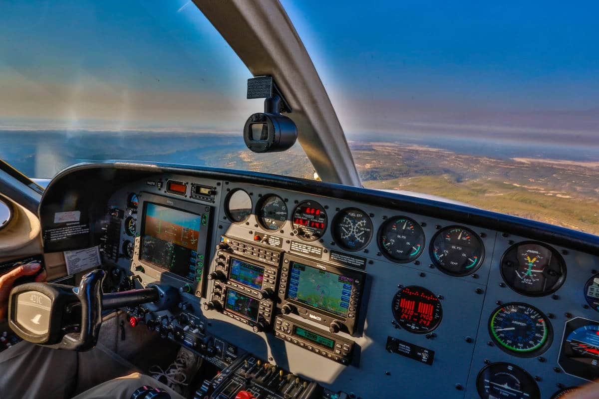 The view, including the instrument panel, from a Cessna 421 Golden Eagle in flight.