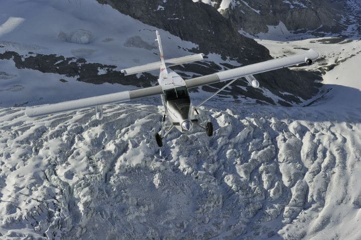 A Pilatus PC-6 Porter flying over the snow