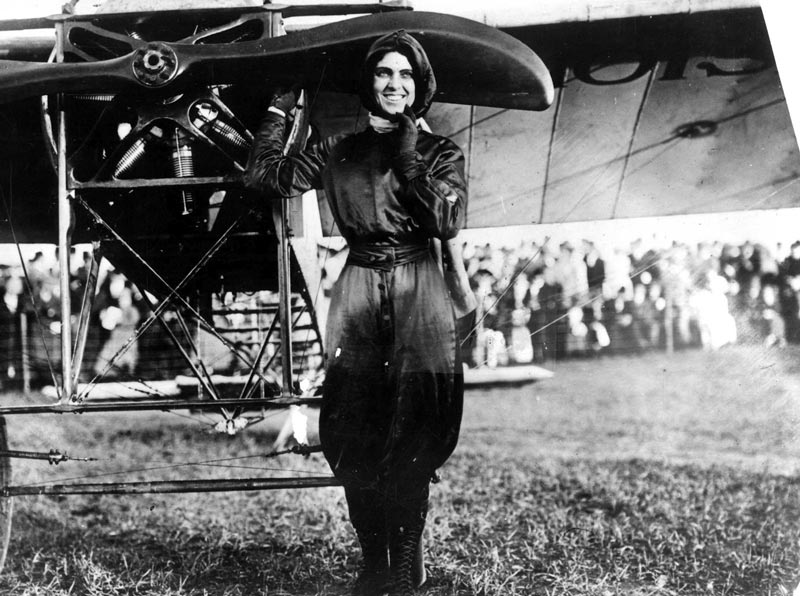Female pilot Harriet Quimby standing next to her aircraft