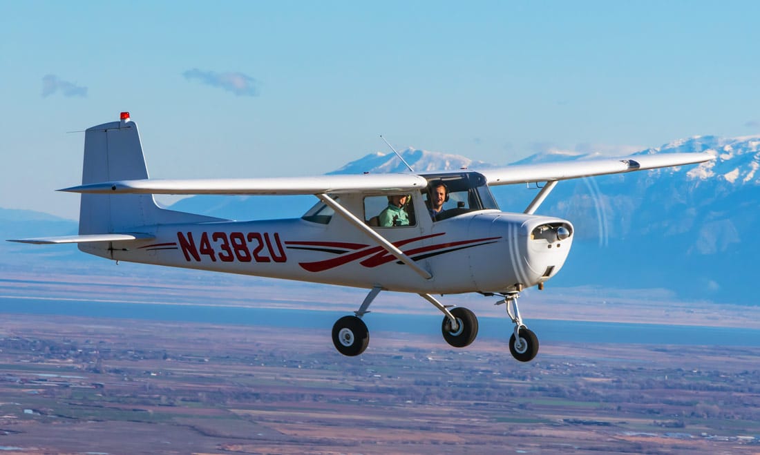 A Cessna 150 flying over the valley - All About the FAA Wings Program