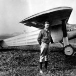 Charles Lindbergh standing next to the Spirit of St. Louis