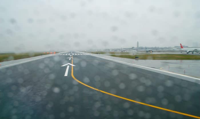 Raining at the airport, which can lead to contaminated runways