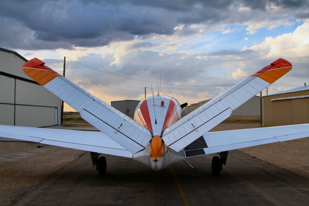 Beechcraft Bonanza parked near aircraft hangars