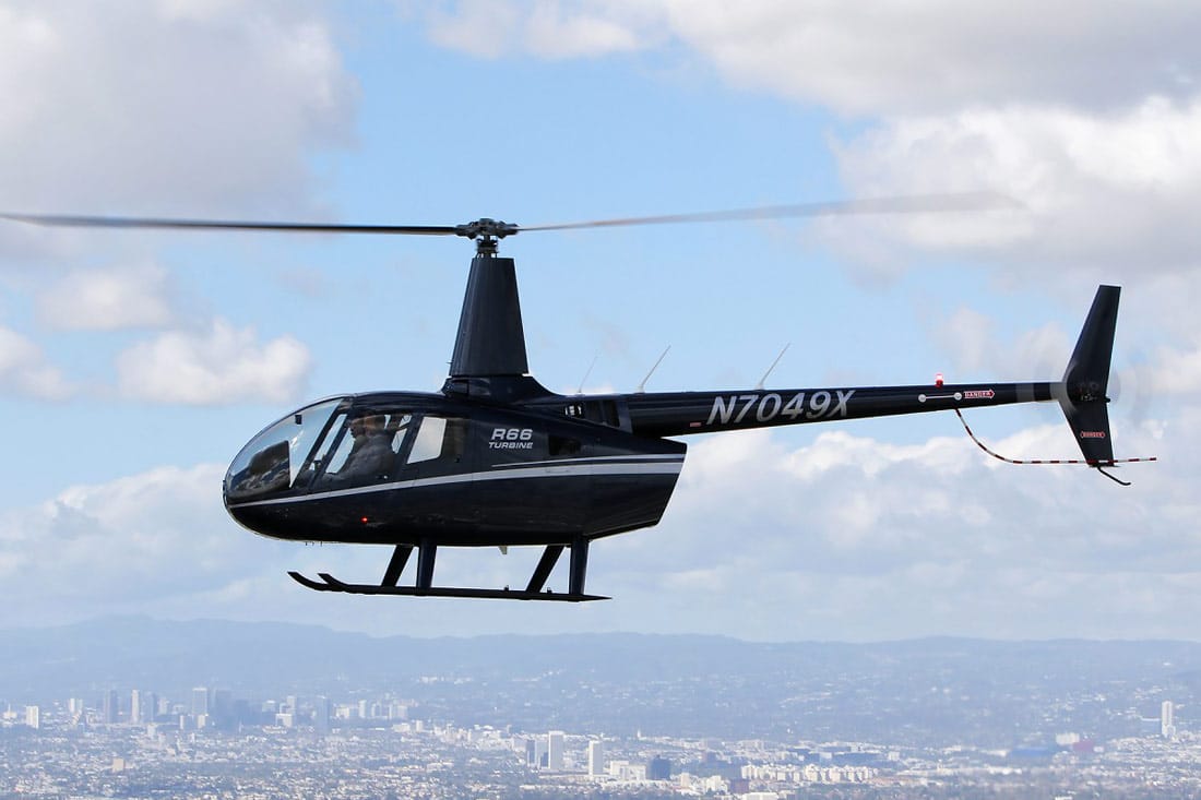 An R66 Helicopter in flight, in midnight blue