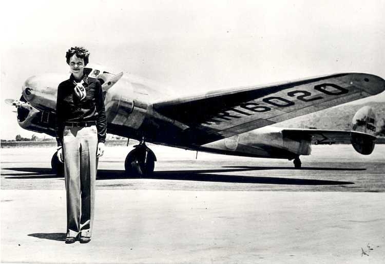 Amelia Earhart, posing with her plane. - Amelia Earhart Search