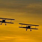 Biplanes flying against a sunset. - 2012 Reno Air Races