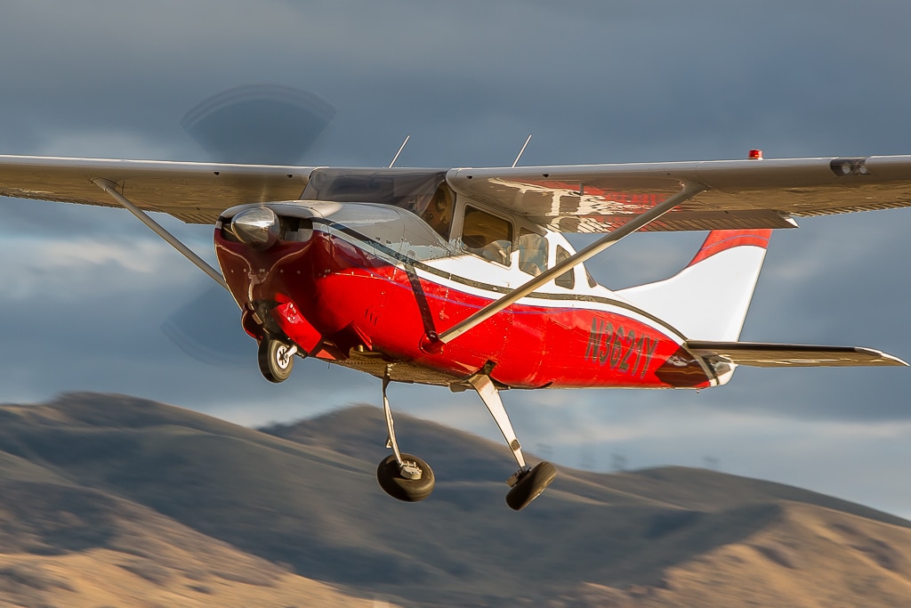 A Cessna 210 Centurion retracting its landing gears after take off