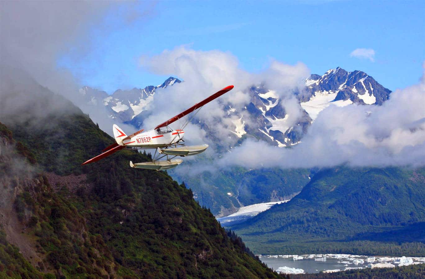 A seaplane flying above the rugged Alaskan terrain.