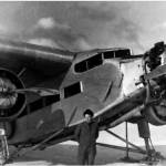 Noel Wien standing next to a Ford Trimotor plane.