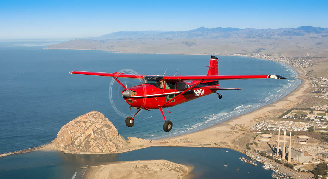 Cessna 180 Skywagon in flight over the coast