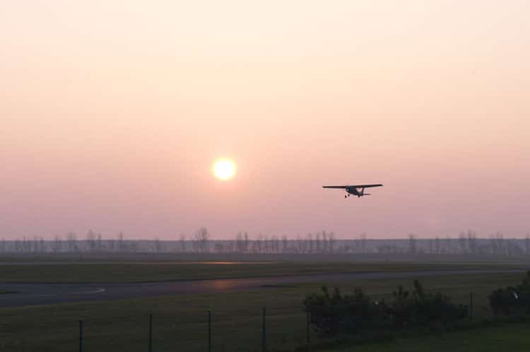 Cessna 152 airplane flying at sunset