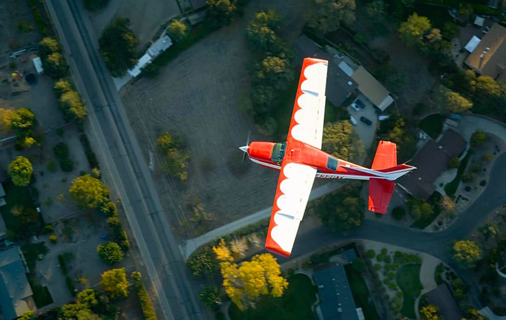 An airplane flying low over a neighborhood experiencing an aircraft engine failure in flight.