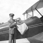 A pilot loading a plane with airmail, part of the history of airmail.